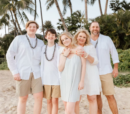 A multi-generational family smiling for the camera during Maui beach photoshoot.