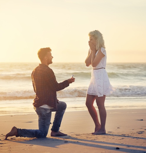 A young man proposes to his partner on West Maui beach.