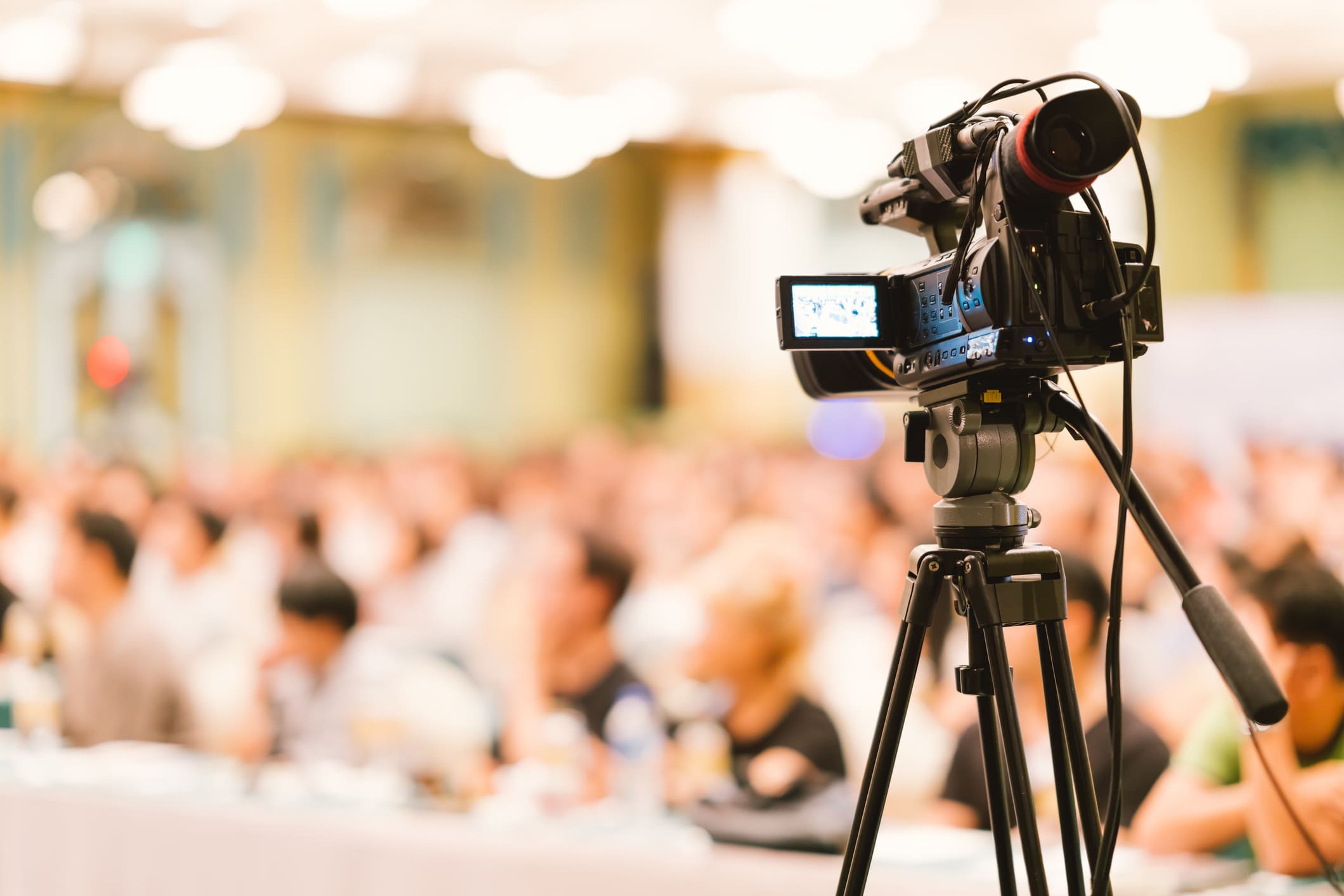Video camera set record audience in conference hall seminar event.