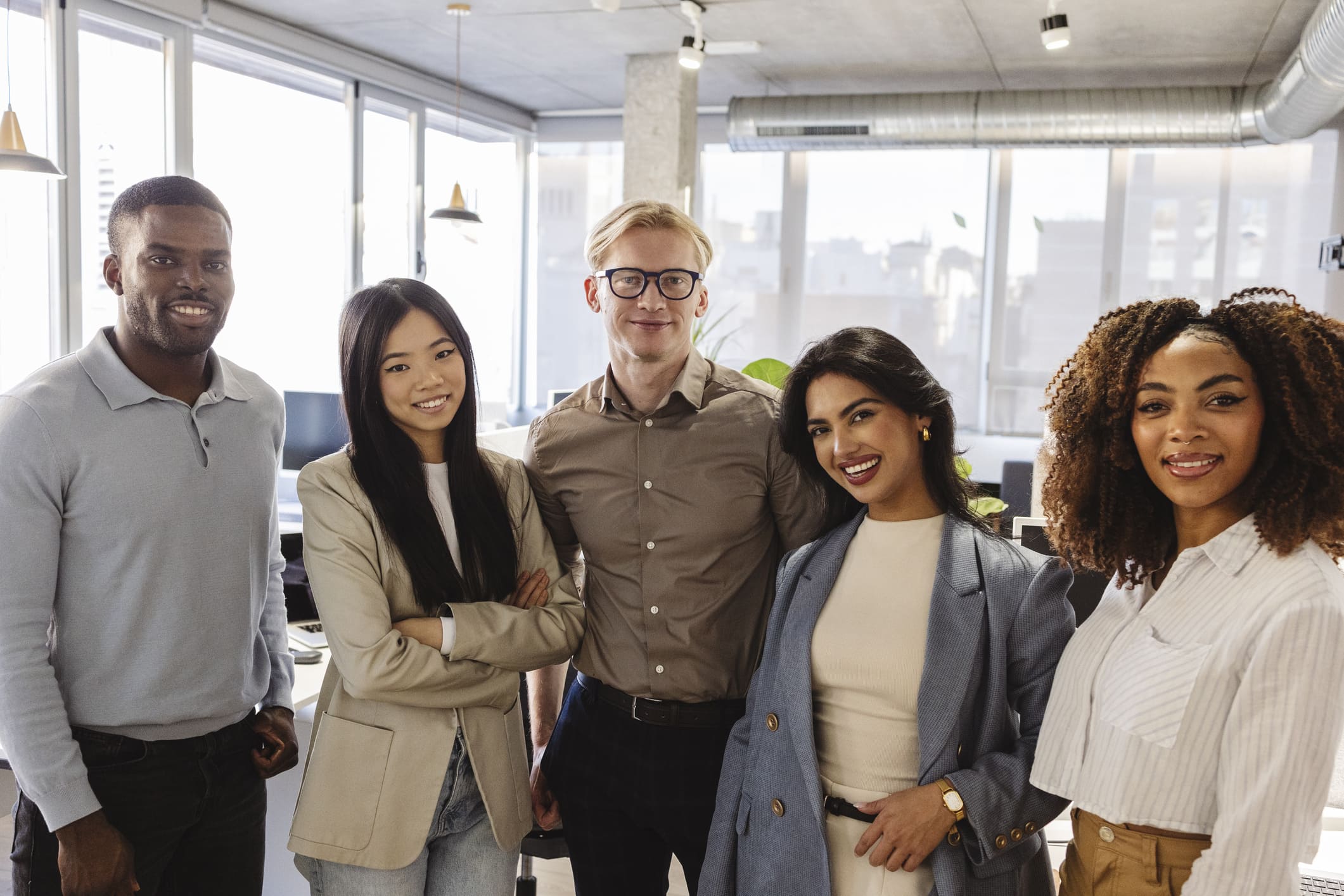 Portrait of smiling team posing together in modern office.